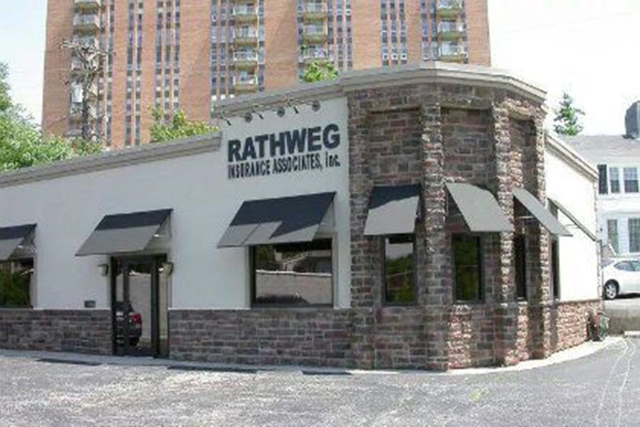 Kettering, OH Insurance - Rathweg Insurance Associates Office Location, a Stucco and Stone Building With Black Awnings Over the Windows